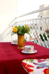 Cup of tea and flowers on a balcony. 