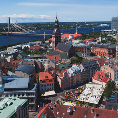 Beautiful super wide-angle panoramic aerial view of Riga, Latvia with harbor and skyline with scenery beyond the city, seen from the St. Peters Church observation tower, sunny summer day