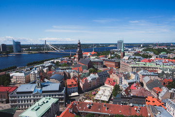 Beautiful super wide-angle panoramic aerial view of Riga, Latvia with harbor and skyline with scenery beyond the city, seen from the St. Peters Church observation tower,sunny summer day 