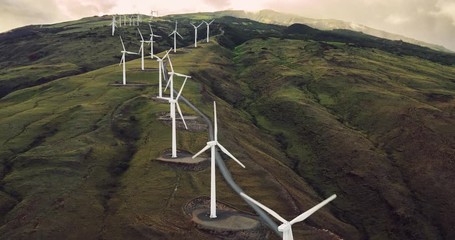 Aerial view of windmills turning at sunset, wind power turbines generate clean renewable energy