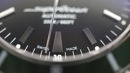 Macro dolly shot of second hand of luxury swiss made watch with green bezel