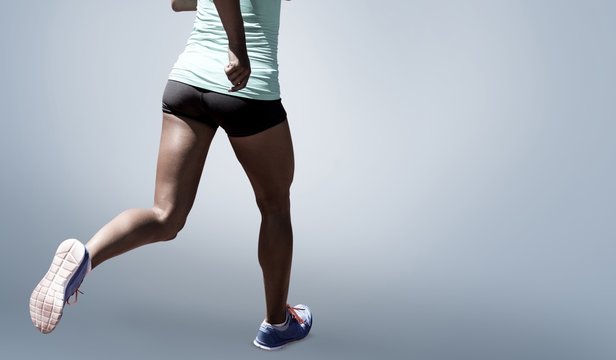 Composite image of rear view of sportswoman running on a white background