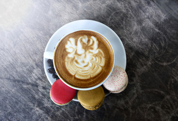 Hot coffee and Macaron on wood table.