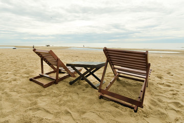 Cloudy sky on the beach with relaxing table and chair