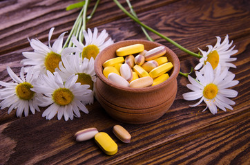 Fototapeta na wymiar Organic pills with camomile