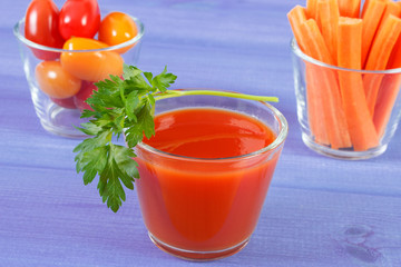 Tomato juice and vegetables on blue board, healthy nutrition