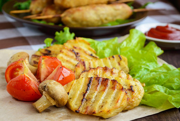 Grilled vegetables: tomatoes, potatoes, mushrooms and herbs. Close-up