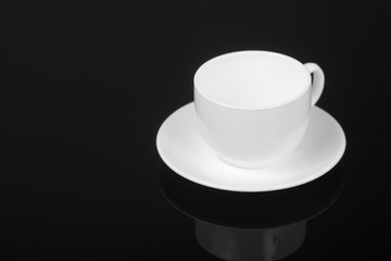 White cup on glossy black background