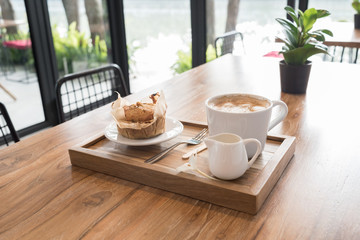 Coffee and muffin on wooden table in coffee shop