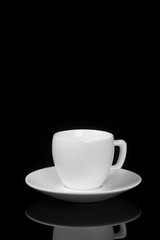 White cup on glossy black background