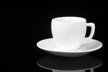 White cup on glossy black background