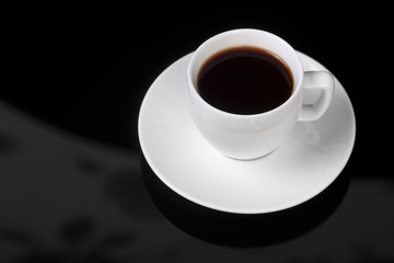 White cup on glossy black background