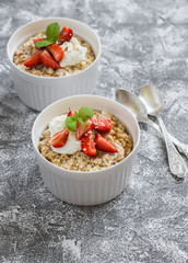 Cottage cheese casserole with strawberries and cream on a grey stone background