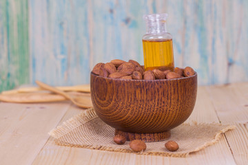 almond oil and  almonds seed on wooden background