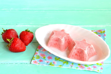 Home pink ice cream shaped star, fresh strawberries. Strawberries mixed with yogurt and sugar and frozen in a freezer. Sweet berry sorbet on a plate