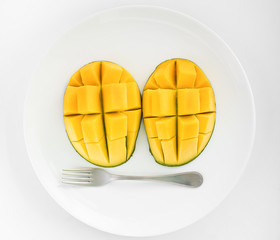 Mango face made on a round white plate with a fork