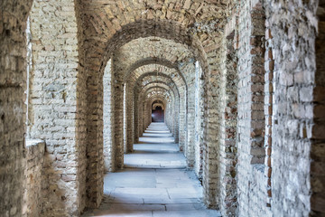 Fototapeta na wymiar Castle tunnel with a series of arches in the ruined Bastion fortress in the Slovak city of Komarno.