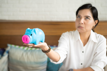 Fototapeta premium woman with piggybank,focus at piggybank blur at woman