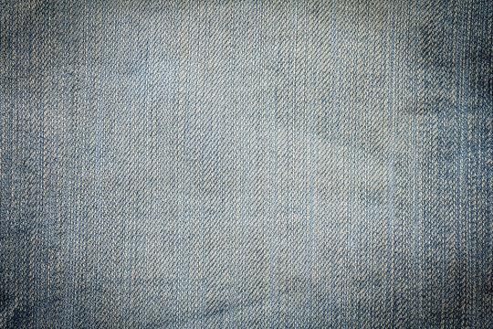 Closeup denim jeans texture. Stitched textured blue denim jeans background. Old grunge vintage denim jeans. Denim jeans fashion design. Dark edged.
