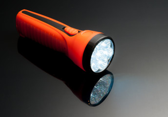 orange led lamps flashlight plastic body on reflected glass back