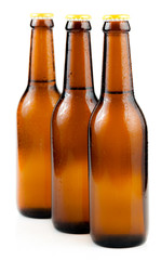 Bottle of beer with drops isolated on white background