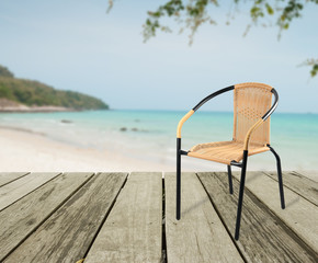 Fototapeta na wymiar artificial rattan chair on wood,sea view background