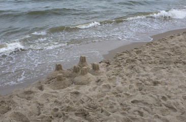 Sand castle on the sea coastline