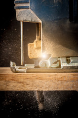 Close up electric jigsaw cutting a piece of wood,action shot