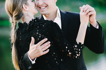 A nice black dressed couple waltzing and laughing,green background
