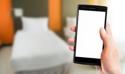 Man's hand holding mobile smartphone,Hotel room background