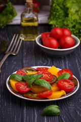 Colorful tomatoes salad in black background