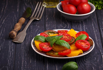 Colorful tomatoes salad in black background