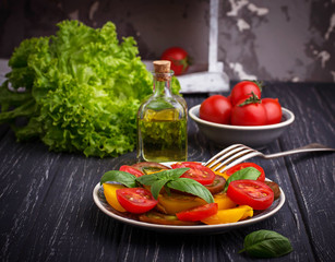 Colorful tomatoes salad in black background