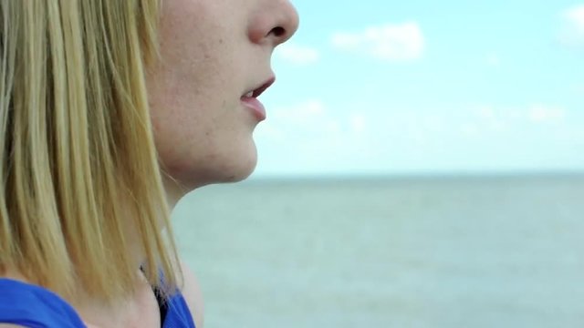 woman smokes an electronic cigarette at sea . девушка курит электронную сигарету на море 