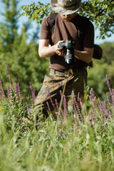 Photographer shooting flowers with DSLR camera in forest
