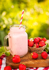 Strawberry smoothie or milkshake in jar on natural background, h