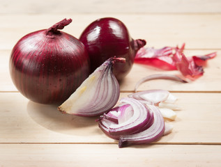 Red onion and cutting board on wooden table, selective focus