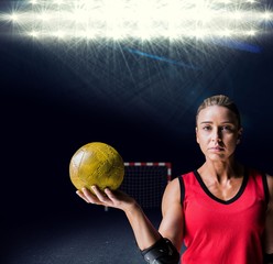 Composite image of female athlete with elbow pad holding handball