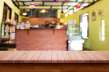 Empty top of wooden table with blur coffee shop background.