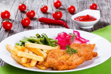 fried pork chop with french fries, green bean and salad