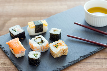 Sushi Set sashimi and sushi rolls served on stone slate