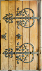 Detail of a wooden door with a handle, wrought iron handle.