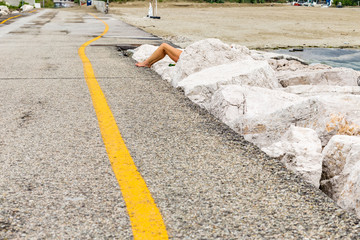 legs sunbathing on rocks of pier