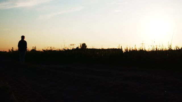 teen girl goes across frame on the dirt rural road pan
