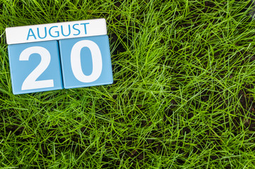 August 20th. Image of august 20 wooden color calendar on green grass lawn background with soccer ball. Summer day. Empty space for text