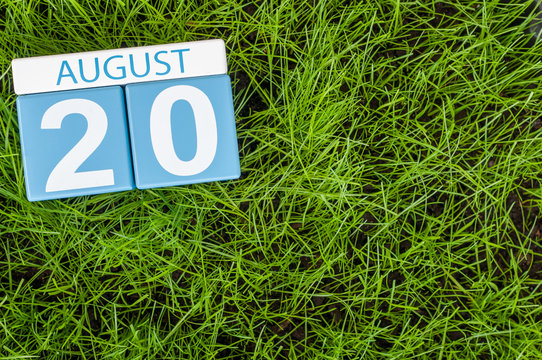 August 20th. Image of august 20 wooden color calendar on green grass lawn background with soccer ball. Summer day. Empty space for text