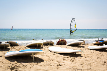 Fototapeta na wymiar Windsurfing board with sail lying on the sand
