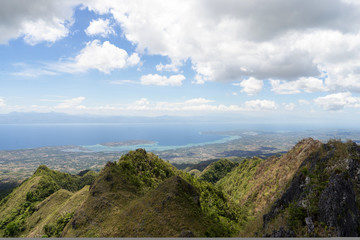 Fototapeta na wymiar View from mountains to tropical sea under cloudy blue sky