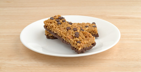 Chocolate chip peanut protein bars on a wood table top side view.