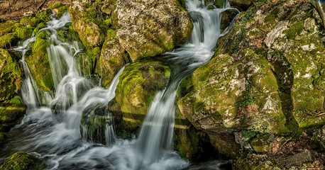 Source of the river that makes waterfalls over rocks covered wit